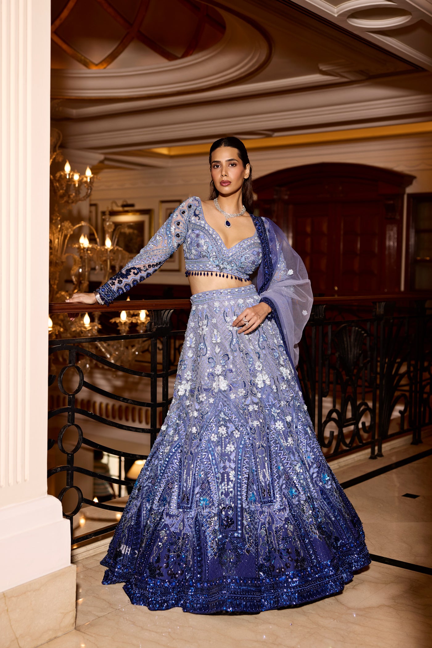 Model wearing blue ombre sequin bridal lehenga with 3D floral embroidery by Opus Atelier, paired with sheer dupatta