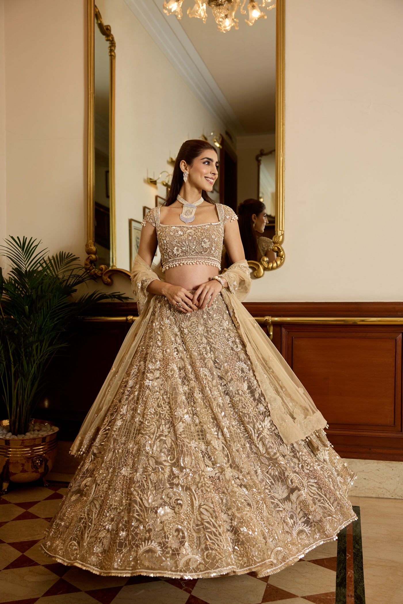 Champagne gold hand-embroidered bridal lehenga with intricate floral motifs and sheer dupatta by Opus Atelier