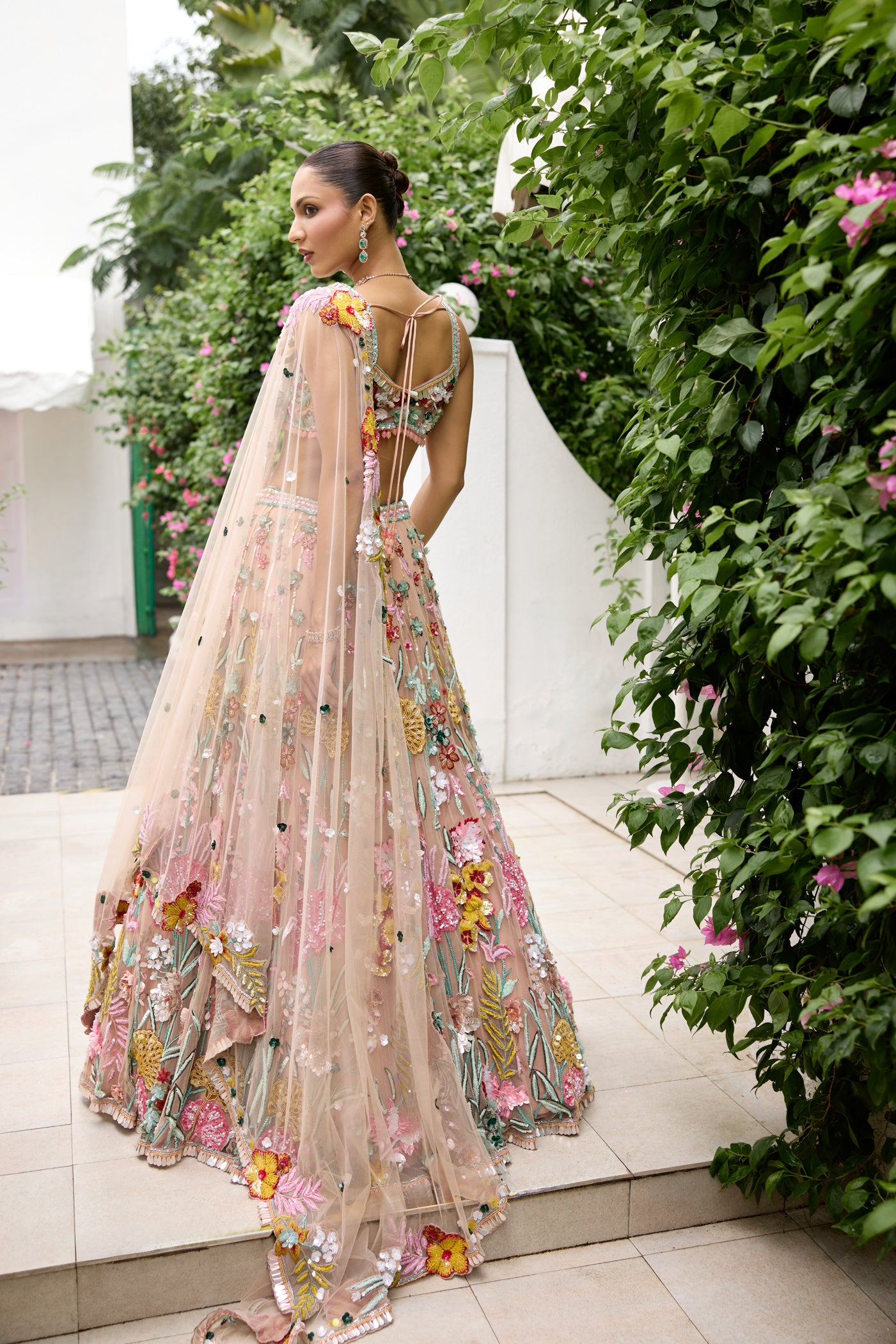 Handcrafted peach lehenga with bold floral embroidery and pastel accents